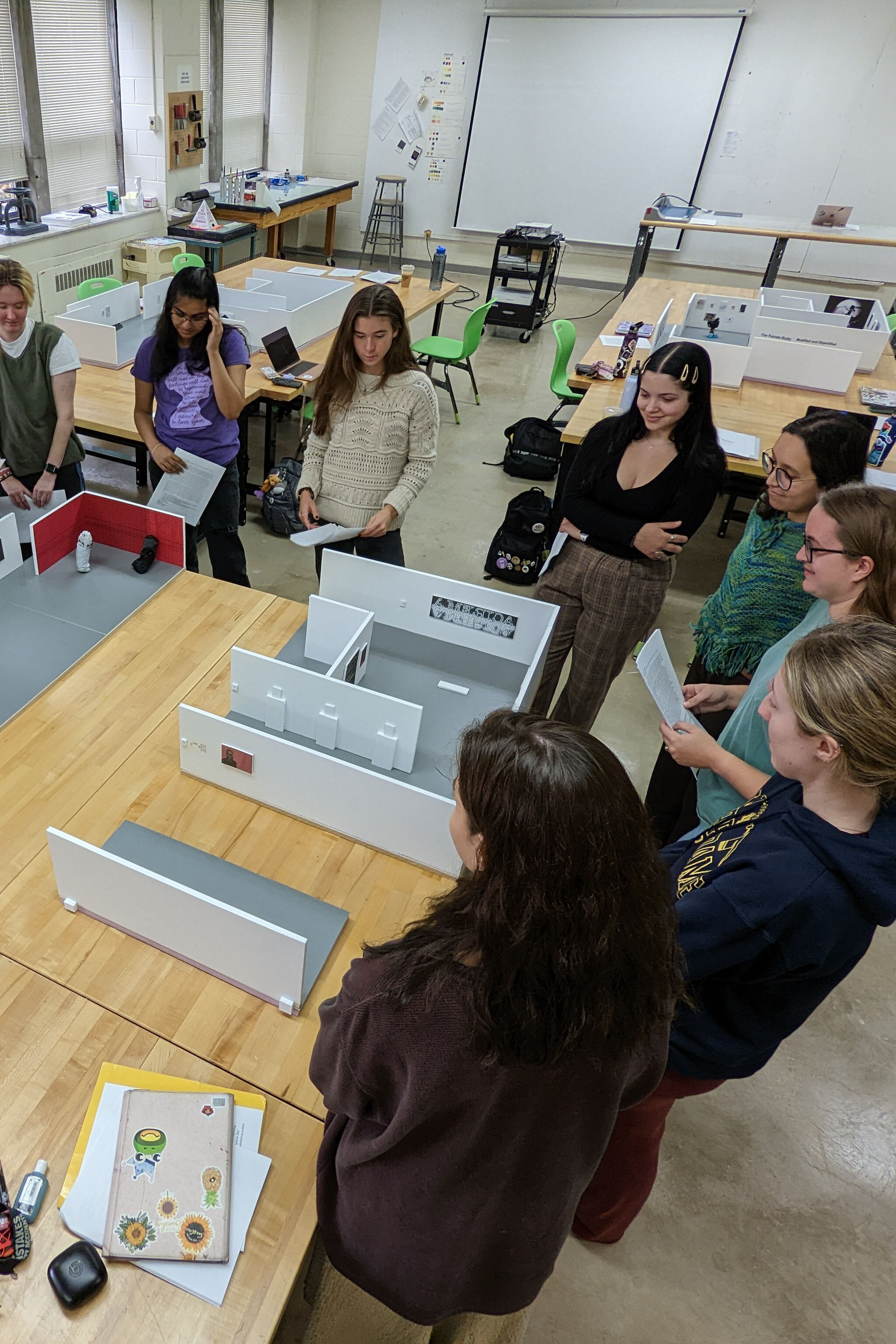 Group of college students standing around a table of open laptops