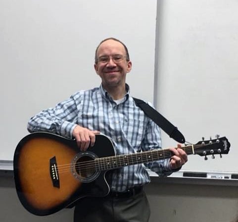 Pictured is James McGrath holding a guitar