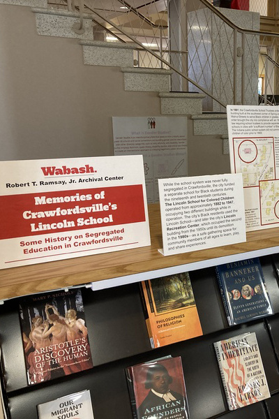 Library bookshelf displaying various books and signs