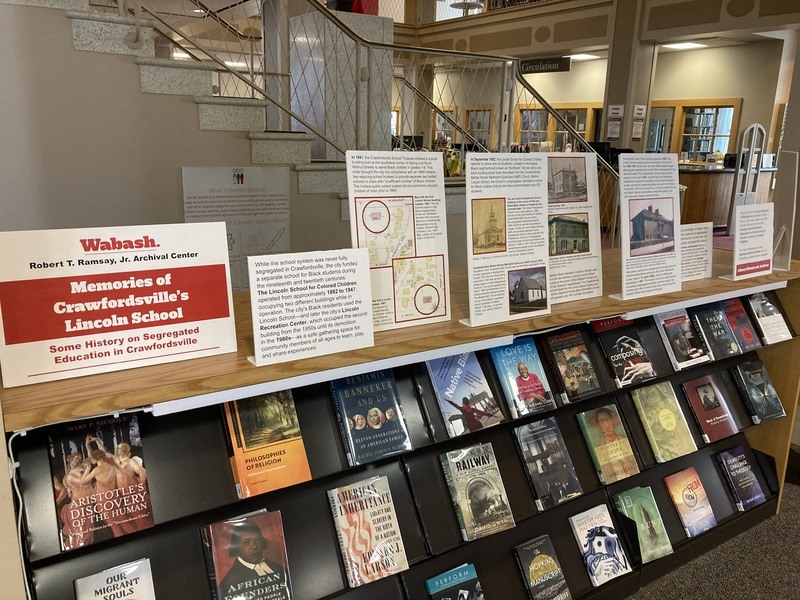 Library bookshelf displaying various books and signs