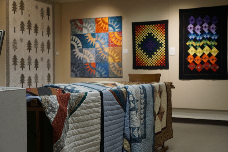 Pictured are various quilts inside an exhibit room
